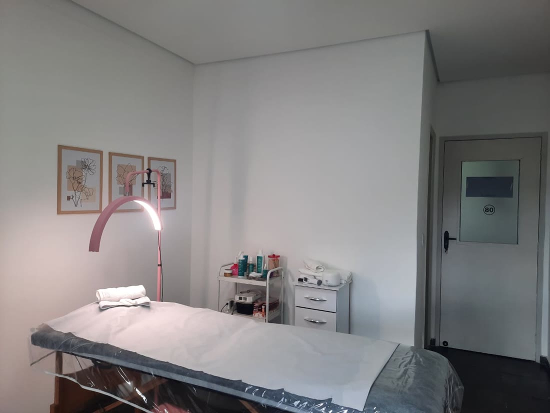 Sala de atendimento da MSS Estética, com maca e luminária